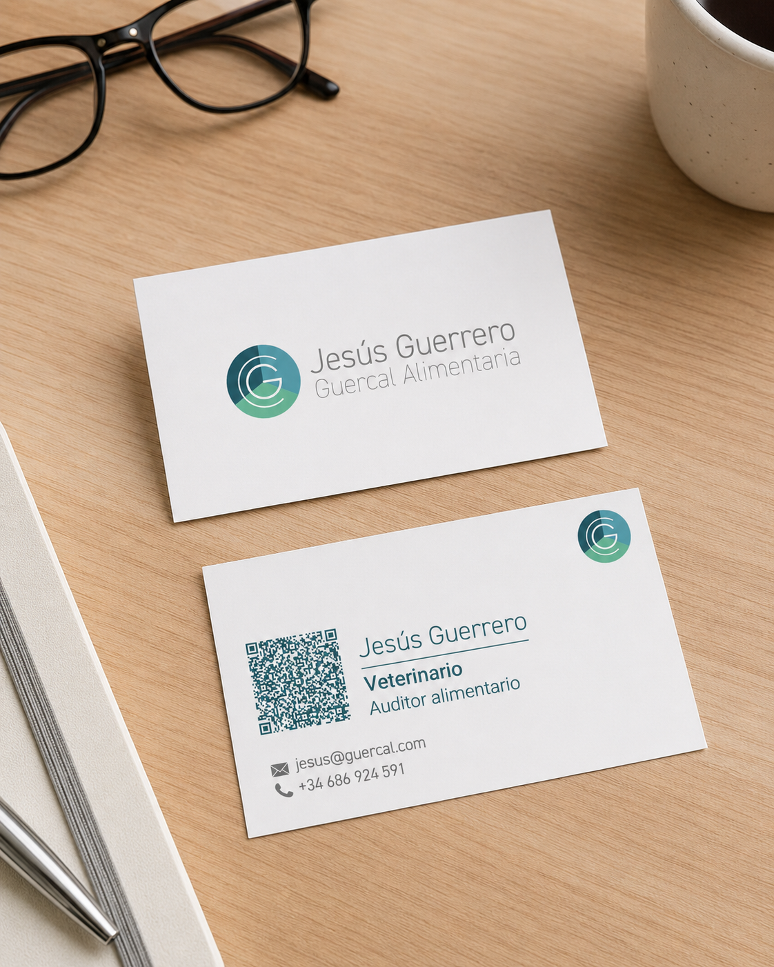 Tarjetas comerciales de Guercal Alimentaria sobre escritorio de madera con gafas y taza