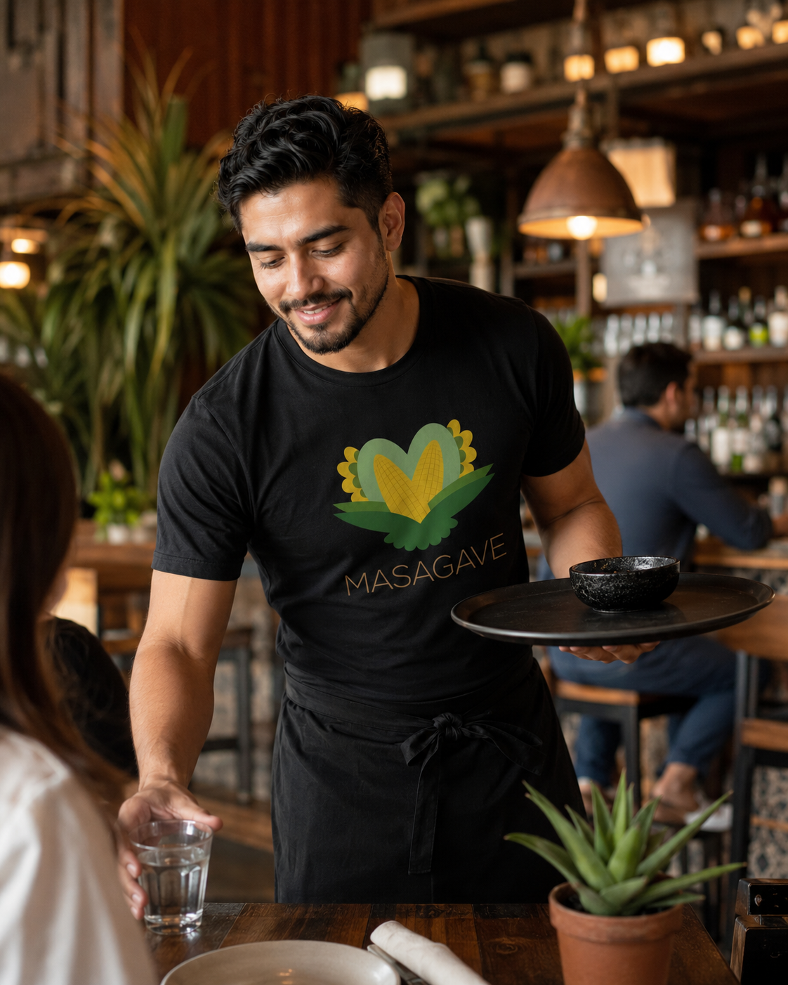 Camarero con camiseta del branding de Masagave en un restaurante