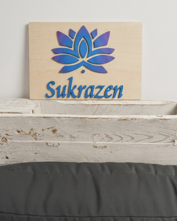 Logo de Sukrazen aplicado sobre maderita en la sala de espera de la clínica