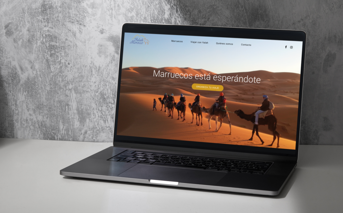 Mockup de la web de YALAH Morocco en un portátil sobre fondo de desierto